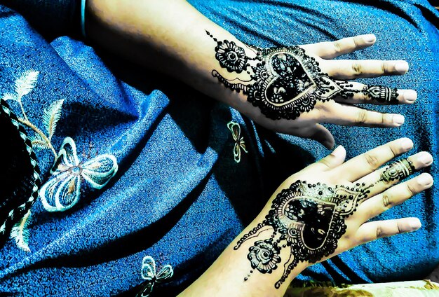 Midsection of woman with henna tattoo o hands