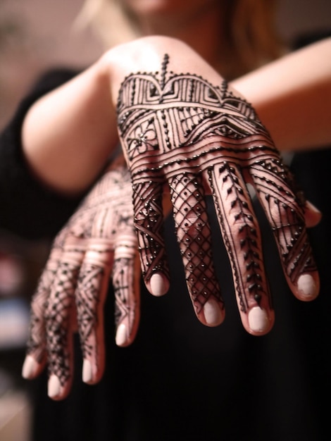 Photo midsection of woman with henna tattoos on hands