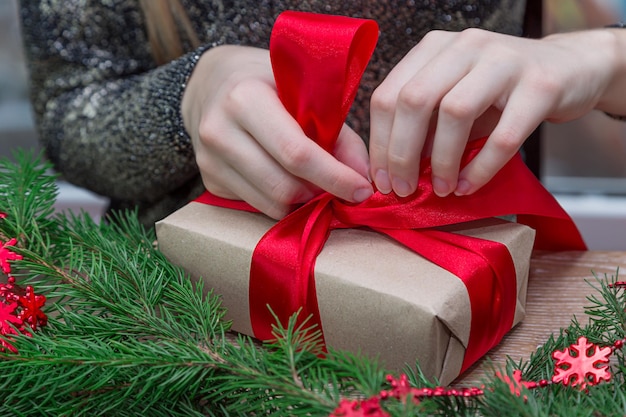 テーブルの上にパッキングクリスマスプレゼントを持つ女性のミッドセクション