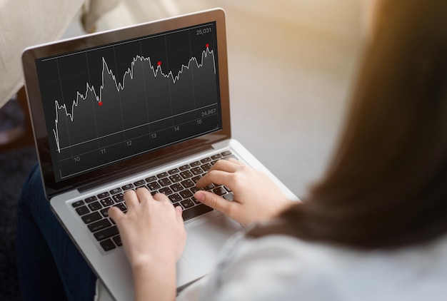 Midsection of woman working over graph in laptop