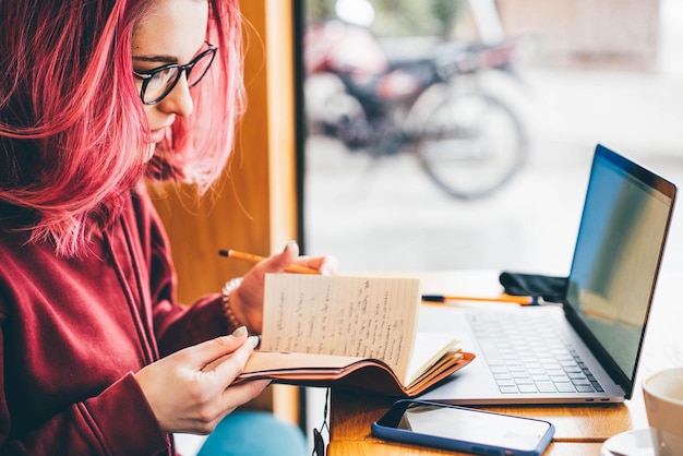 Photo midsection of woman writing in book