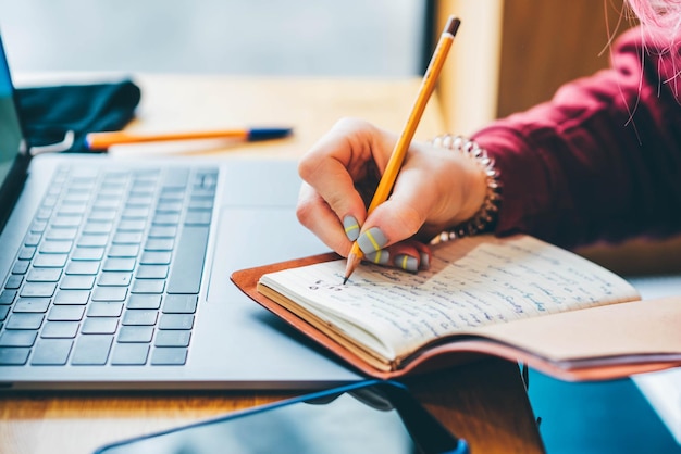 midsection of woman writing in book
