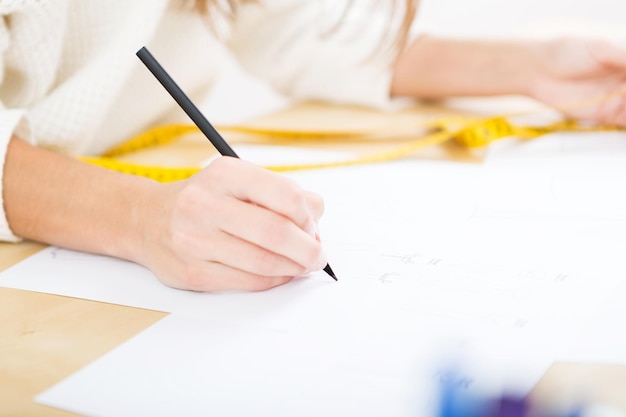 Foto sezione centrale di una donna che scrive su carta alla scrivania dell'ufficio