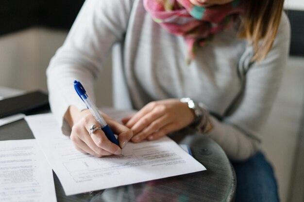 Foto sezione centrale di una donna che scrive su carta al tavolo