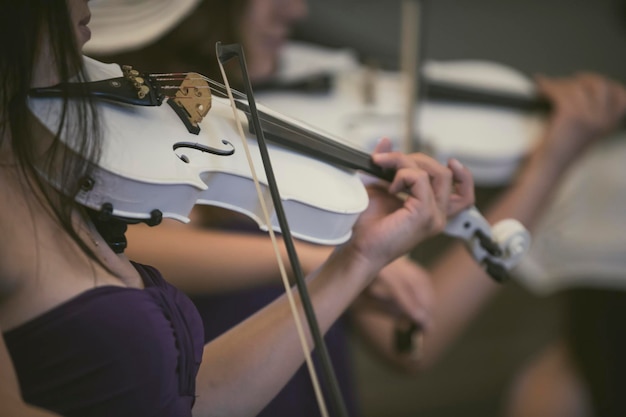 Midsection of women playing violins at music concert