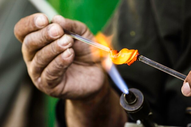 Midsection of worker making glassware in factory