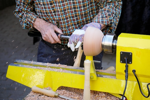 Midsection of worker turning lathe