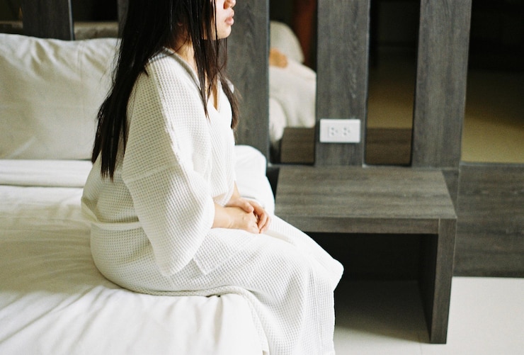 Photo 家のベッドに座っている若い女性のミッドセクション