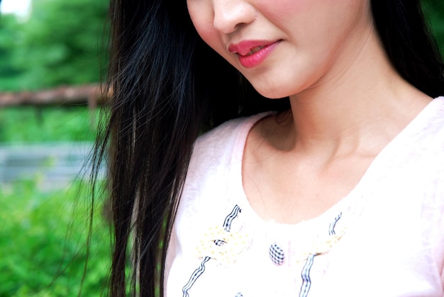 Midsection of young woman with long hair standing in park