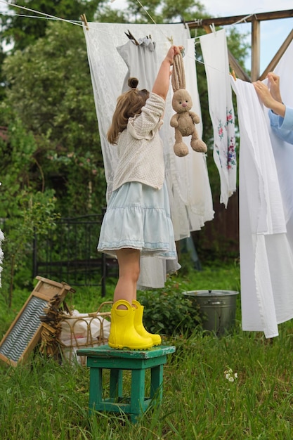 Midst the greenery a cheerful child turns laundry time into a delightful game attempting to hang her