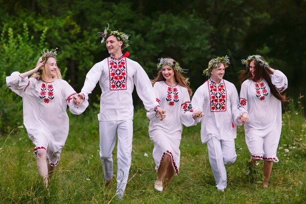 Midsummer, People running in nature in Slavic clothes.