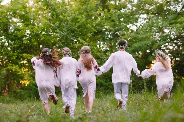 Midsummer, People running in nature in Slavic clothes.