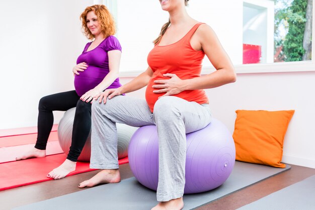 Midwife coaching expectant mothers during relaxation exercises 