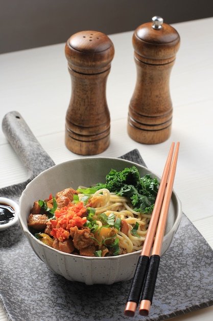 Mie Ayam, Indonesian Popular Street Food with Noodle, Chicken, and Green Vegetables with Delicious Broth