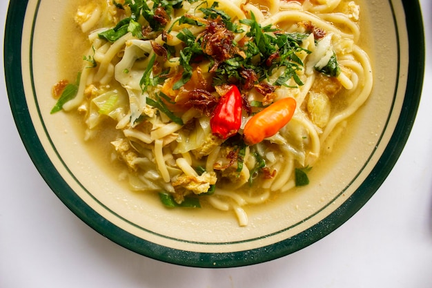 Photo mie godog jawa or bakmi jawa or java noodle or mie rebus or boiled noodles with spoon and fork indonesian traditional street food noodles from java indonesia on white backgroud