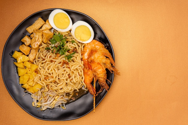 Mie rebus medan of Noedelsoep Het gerecht is gemaakt van gele eiernoedels die ook in Hokkien mee worden gebruikt met een pittige lichtzoete curry-achtige jus De jus is gemaakt van garnalen- of tauchubouillon