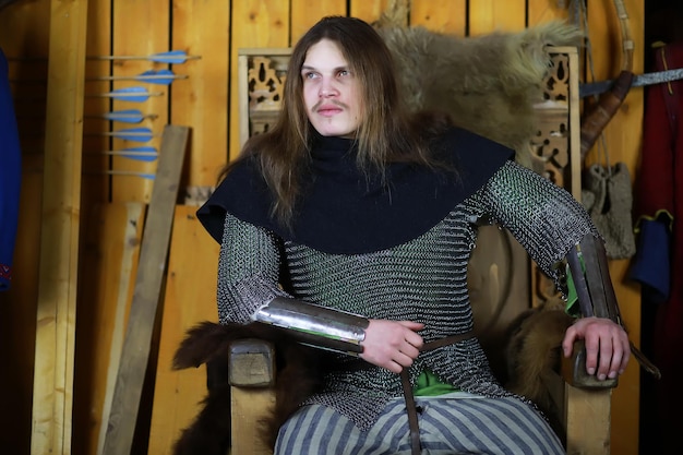 A mighty hero with long hair in chain mail armor in an ancient hall Medieval warrior