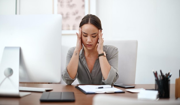 Migraine headache and business woman in office with online career burnout mental health risk and mistake Brain fog problem or pain of asian person or employee massage temple fatigue and stress
