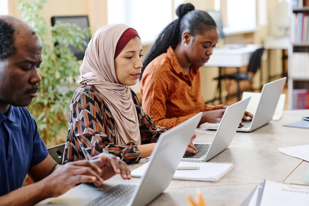 Migrantenstudenten die laptops gebruiken