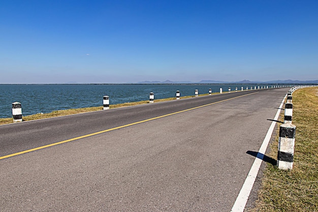 Mijlpalenzwarte en witte mijlpalen langs de weg met blauwe lucht langs de weg langs de weg in het achtergrondconcept voor de volgende stap