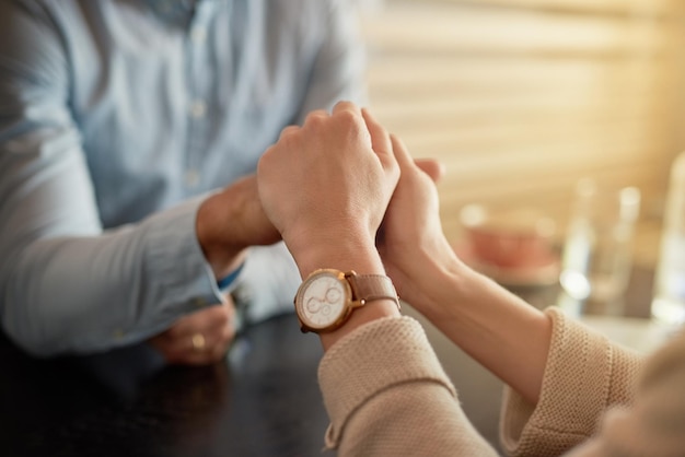 Mijn hand voor altijd in de jouwe Shot van een aanhankelijk jong stel dat elkaars hand vasthoudt terwijl ze in een café zitten