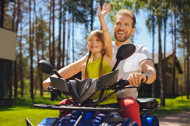 Mijn hobby. inhoud charmant meisje glimlachend en atv rijden met haar vader