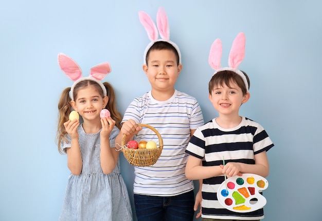 Mijn lieve kinderen met paaseieren en verfpalet op kleur oppervlak