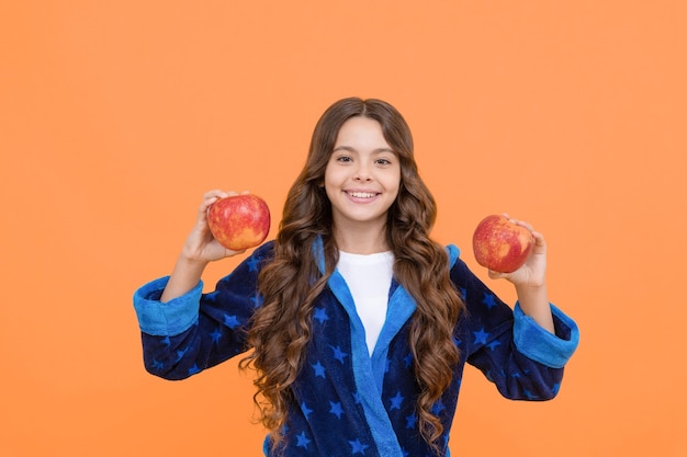Mijn voedingskeuze vrolijke tienermeisje gaat appeltanden eten in nachtkleding glimlachend kind ontbijten in huiskleding jeugdgezondheidszorg en biologisch dieet natuurlijke gezonde voeding