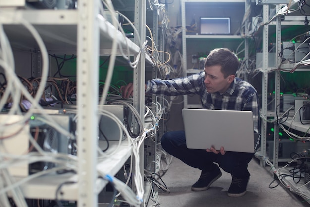 Mijnbouw. Een man die op een boerderij werkt voor de winning van cryptovaluta's. Bitcoin bedrijf