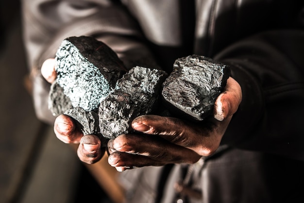 Mijnbouw mijnwerker in de handen van de man van kolen achtergrond. Foto-idee over kolenwinning of ener