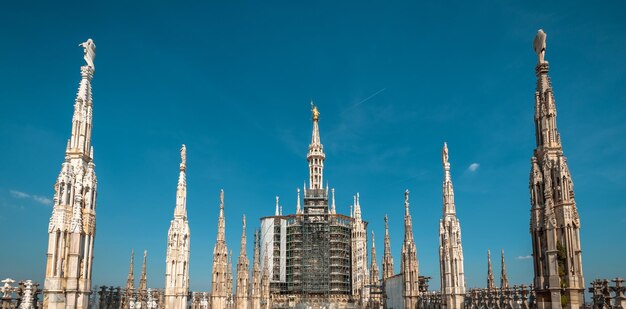 ミラノ大聖堂の屋根イタリア有名なミラノ大聖堂またはミラノのドゥオーモは、街のトップランドマークです豪華な尖塔と中央のマドンナ像のパノラマビュー