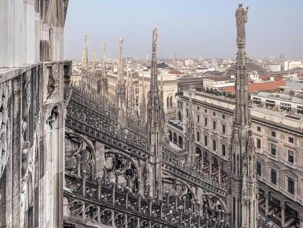 イタリアのドゥオモカトリック大聖堂の美しいゴシック建築の日の出のミラノの屋根から眺める