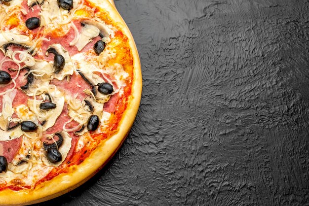 Milanese pizza on a black background, tomato-based with mozzarella