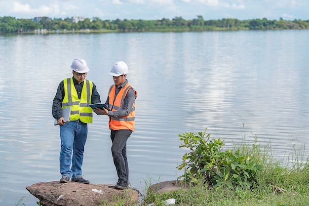 Milieu-ingenieurs inspecteren de waterkwaliteitBreng water naar het laboratorium om te testenControleer het mineraalgehalte in water en bodemOverleg om het probleem van chemisch verontreinigde waterbronnen op te lossen