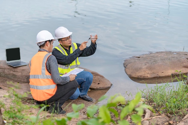 Milieu-ingenieurs inspecteren de waterkwaliteitBreng water naar het laboratorium om te testenControleer het mineraalgehalte in water en bodemOverleg om het probleem van chemisch verontreinigde waterbronnen op te lossen