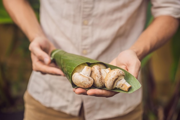 Milieuvriendelijk productverpakkingsconcept champignons verpakt in bananenblad als alternatief voor a