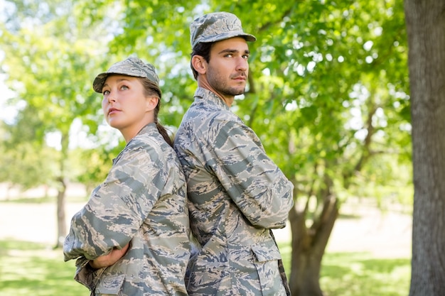 Militair paar die zich met wapens bevinden die in park worden gekruist