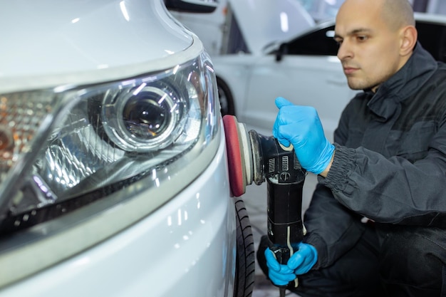 Militair polijsten carrosserie met machine in een werkplaats.