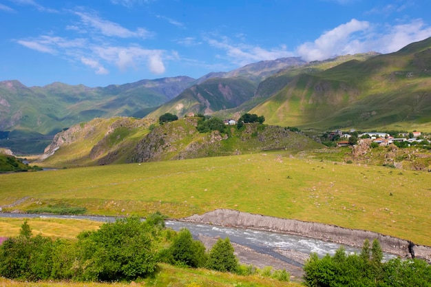 Militaire Georgische weg Een prachtig berglandschap met een stromende rivier en een klein dorpje