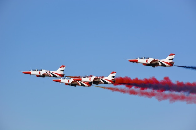 Militaire gevechtsvliegtuigen vliegen in een groep met rook in de blauwe lucht