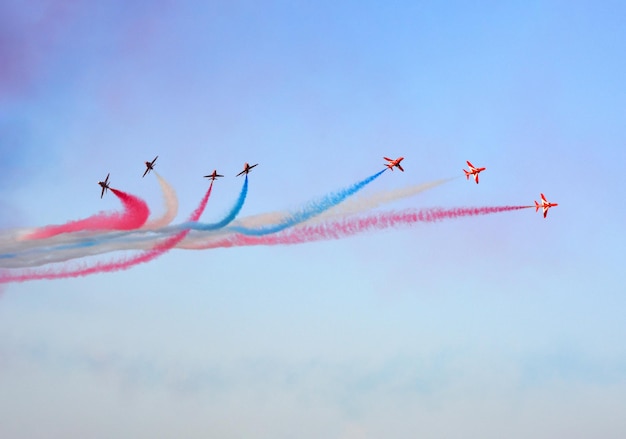 Militaire gevechtsvliegtuigen vliegen in een groep met rook in de blauwe lucht
