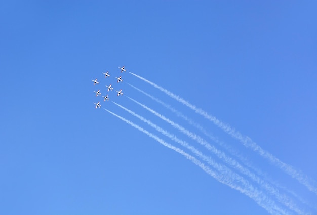 Militaire gevechtsvliegtuigen vliegen in een groep met rook in de blauwe lucht