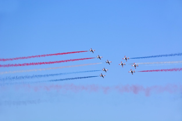 Foto militaire gevechtsvliegtuigen vliegen in een groep met rook in de blauwe lucht