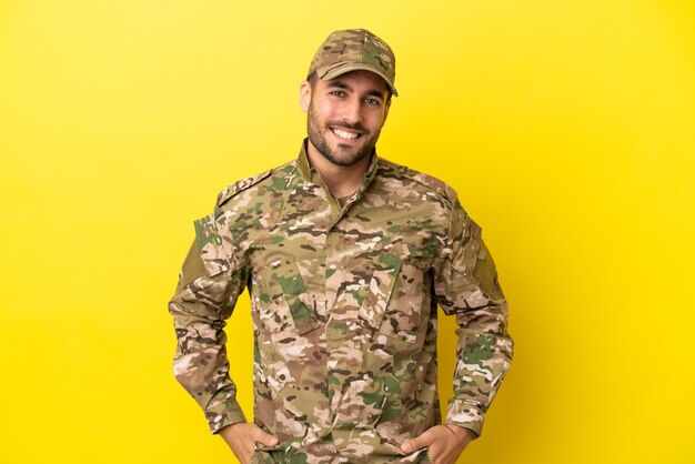 Militaire man geïsoleerd op gele achtergrond lachen