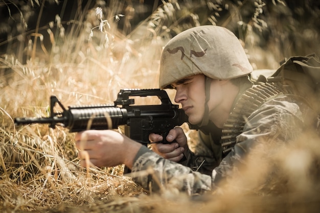 Militaire soldaat gericht met een geweer in laarskamp