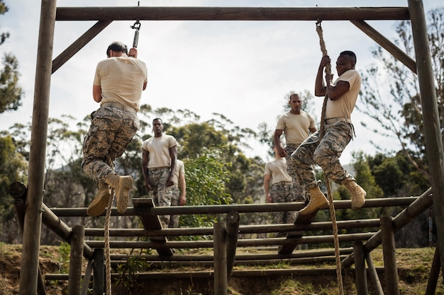 Militaire soldaten die touwklimmen trainen