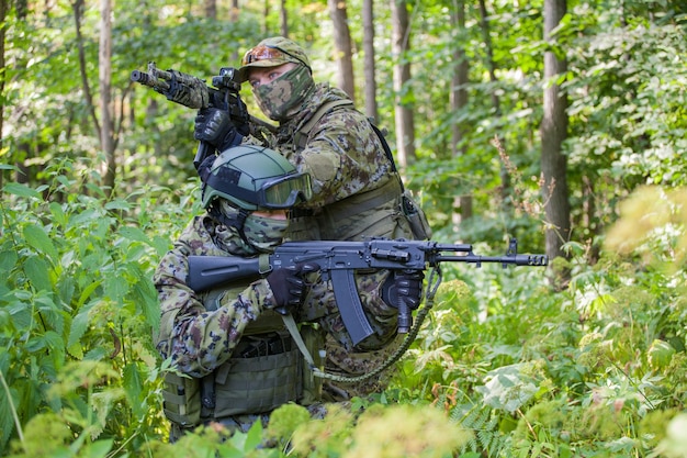 Militairen in het bos met een machinegeweer. Soldaten zijn klaar voor actie