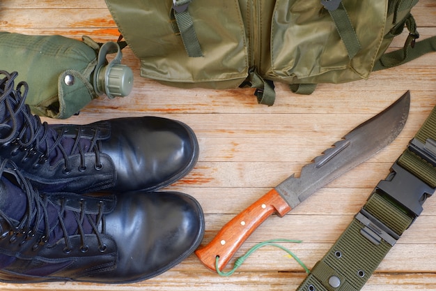 Military back pack for soldier, boots,canteen on wooden backgroud