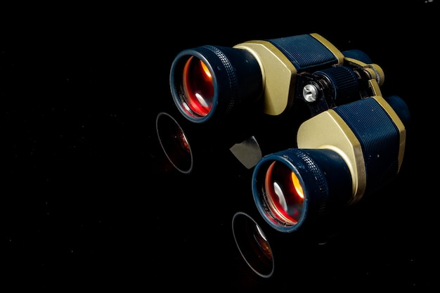 Military binoculars on black background close up