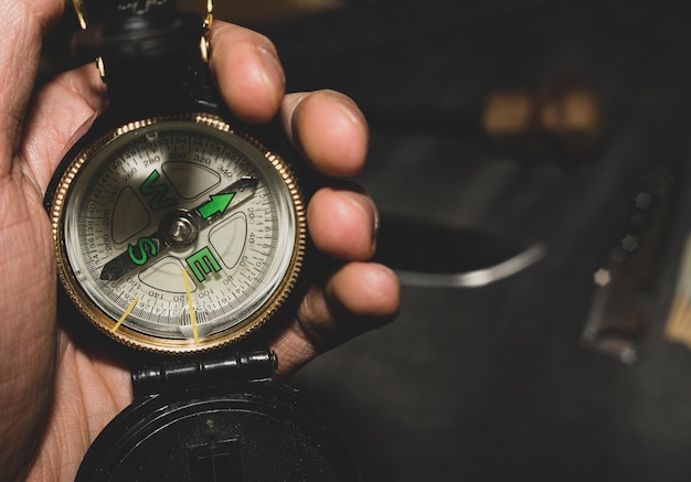 military compass in hand bushcrafters holding compass in hand on background of the knife and flint